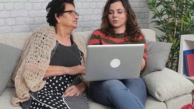 和奶奶一起使用笔记本电脑的女孩视频素材