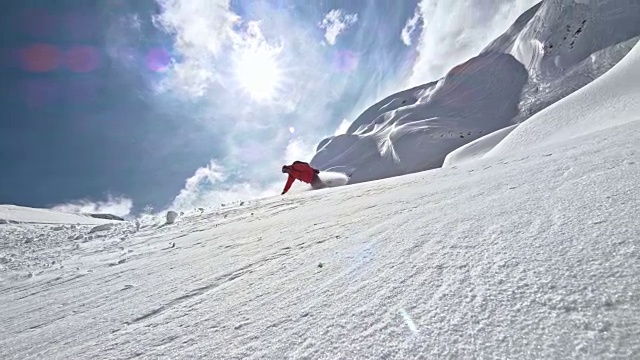SLO MO滑雪板在阳光明媚的山坡上坠落视频素材
