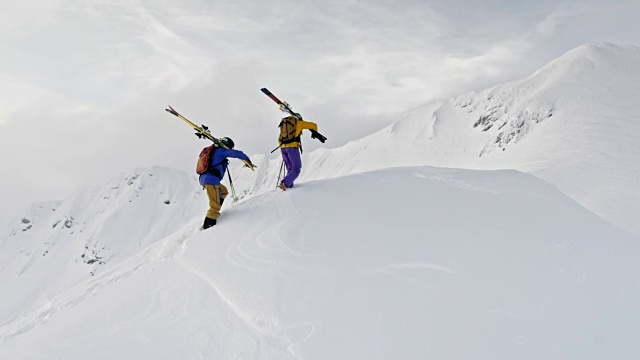 两个偏远地区的滑雪者在山脊上行走视频素材