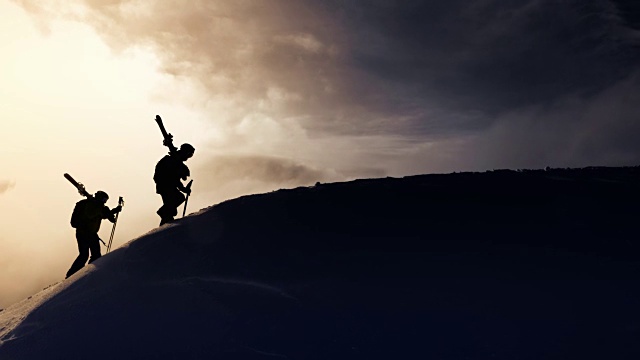 空中剪影的偏远滑雪者上行的山脊视频下载