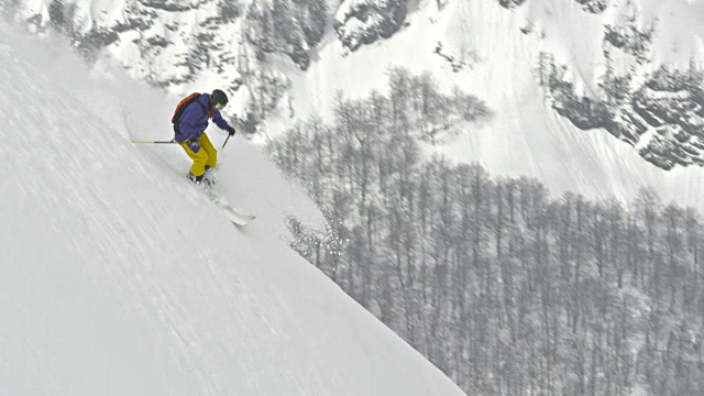 SLO MO Man在粉雪中滑下山坡视频素材