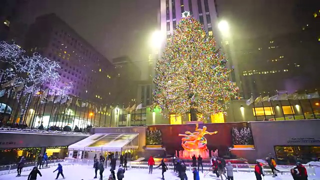 照相机捕捉到了人们在曼哈顿中城洛克菲勒中心的溜冰场享受雪夜滑冰的情景。视频素材
