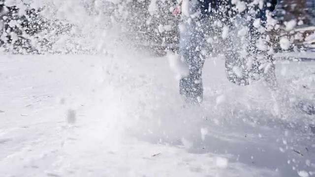 年轻女子在没过膝盖的雪中奔跑视频素材