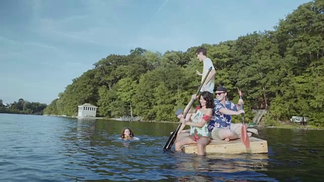 朋友们在湖中的浮码头上划桨视频素材