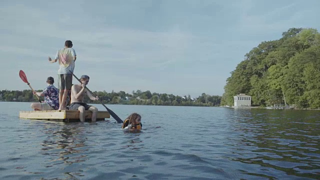 朋友们在湖中的浮码头上划桨视频素材