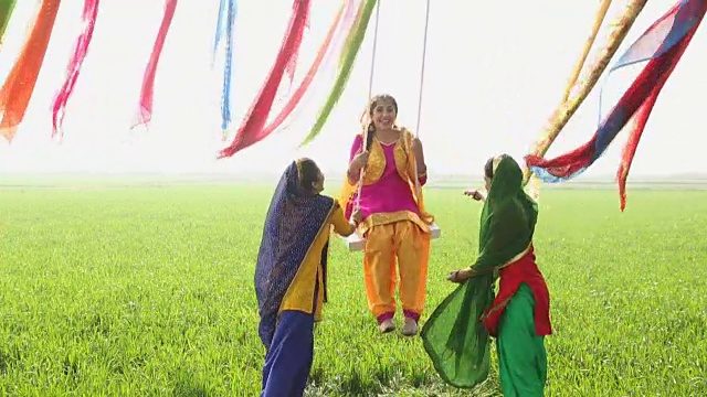 在印度旁遮普的农场里，三名旁遮普年轻妇女在绳上荡秋千视频下载