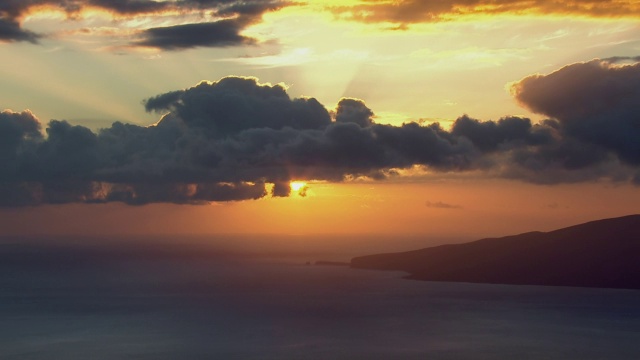 鸟瞰图日落在太平洋与夏威夷岛的剪影对多云的天空。视频素材