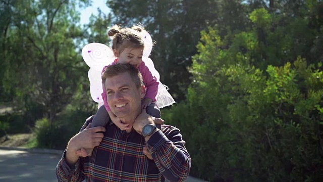 爸爸抱着穿着仙女服的小女儿。视频下载