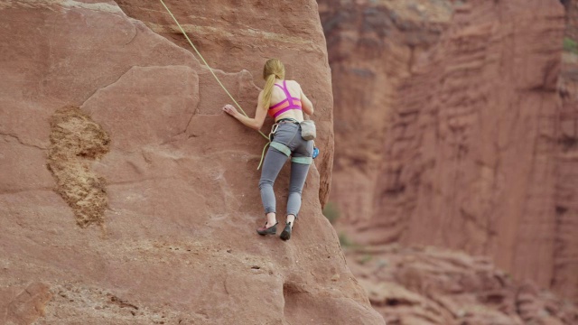 妇女在岩石上的广角镜头/费舍尔塔，犹他州，美国视频素材