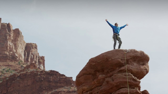 广角低平移拍摄的人庆祝岩石形成/费舍尔塔，犹他州，美国视频素材