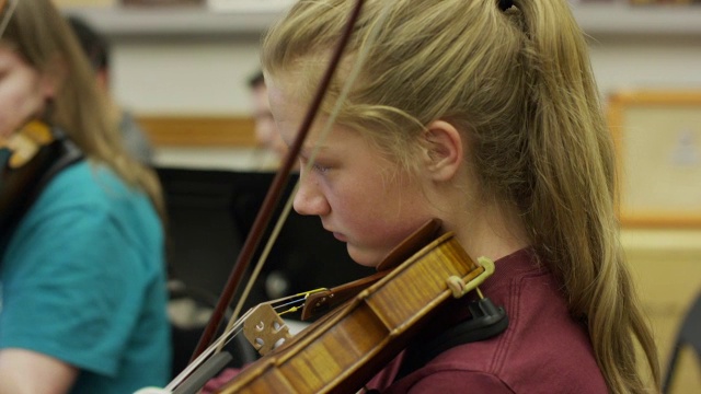 特写镜头的少女在管弦乐队演奏小提琴的练习/美国叉，犹他州，美国视频素材