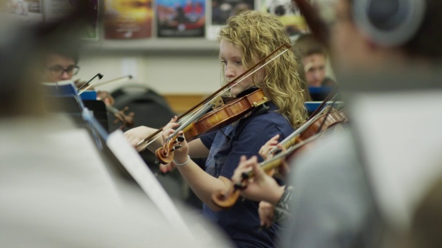 少女在管弦乐队演奏小提琴的中镜头/美国犹他州的美国叉视频素材