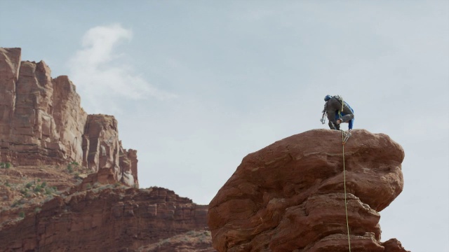 广角低平移拍摄的人站在岩层/费舍尔塔，犹他州，美国视频素材