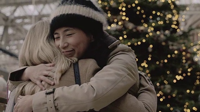 圣诞节期间，一名女子在火车站问候并拥抱她的朋友。视频下载