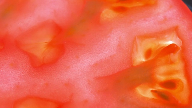 成熟红番茄果肉的内部剖视图。背光水果转动缓慢视频下载