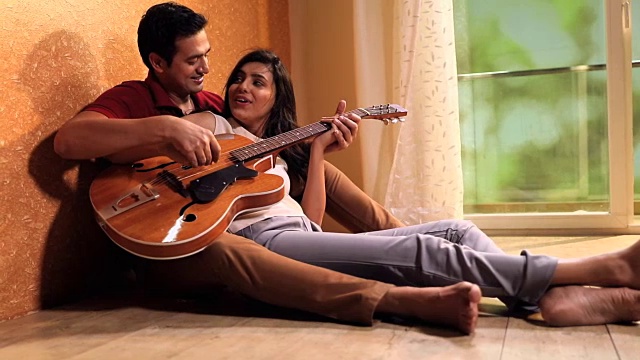 一对夫妇在家里弹吉他，德里，印度视频素材