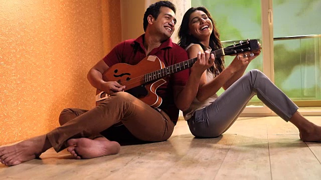 一对夫妇在家里弹吉他，德里，印度视频素材