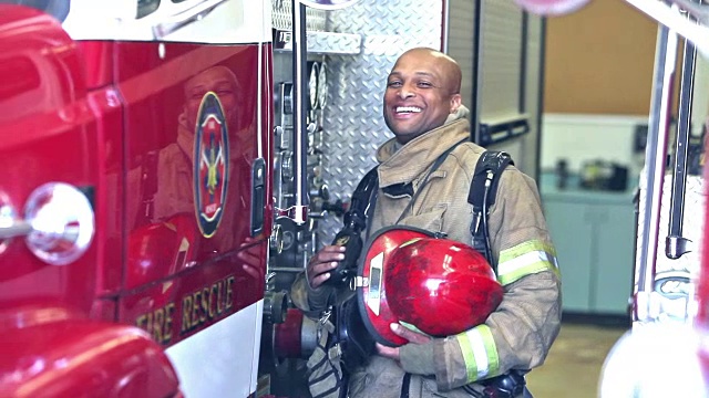 非裔美国消防员站在车站的卡车旁视频下载
