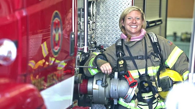 女消防员站在消防车旁视频素材