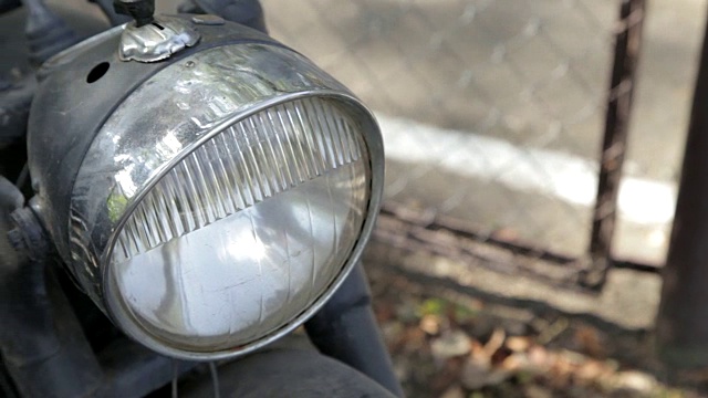 一辆旧摩托车的前灯上的跟踪镜头。视频下载