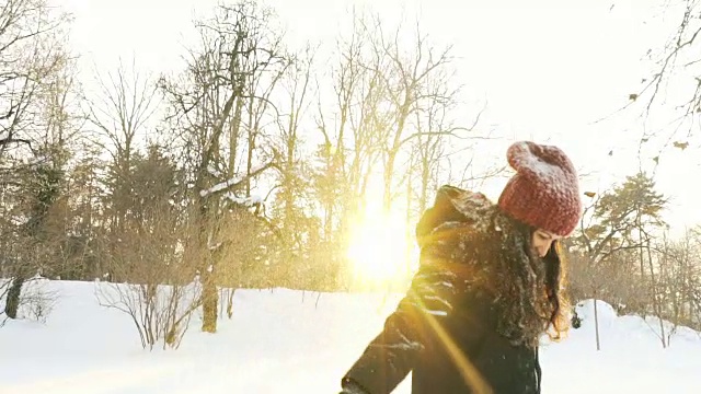 快乐的年轻女子用超慢的动作玩雪。视频素材