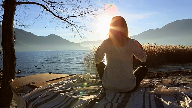 日落时分，年轻女子在湖边做瑜伽视频下载