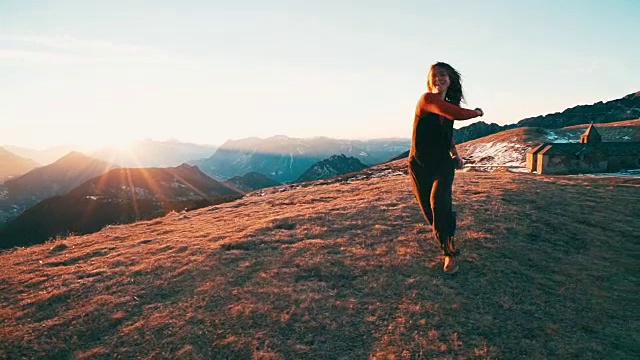 日出时，年轻女子在山顶跳舞视频素材