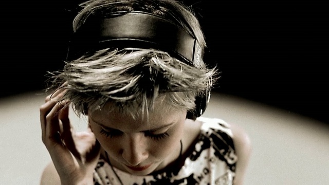 近高角度的女人与短金发+眼睛闭上戴耳机移动头与音乐视频下载