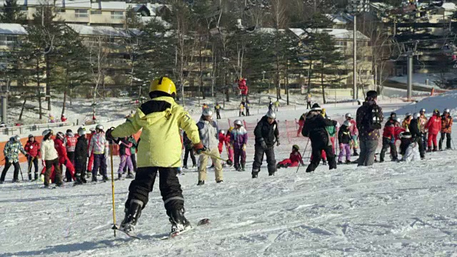 平昌(2018年冬奥会)，孩子们穿着滑雪板侧身上山视频下载