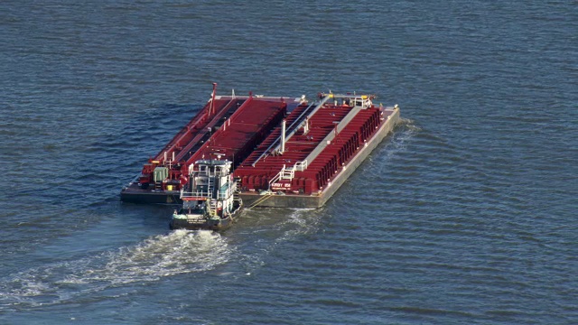 一艘拖船推着一艘驳船穿过休斯敦航道。视频素材