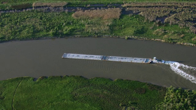 一艘拖船将一艘驳船推下德克萨斯河。视频素材