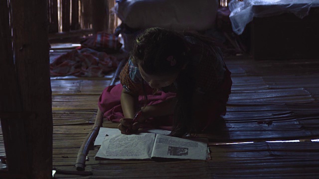 一个缅甸女孩在地板上做作业，传统的房子视频下载