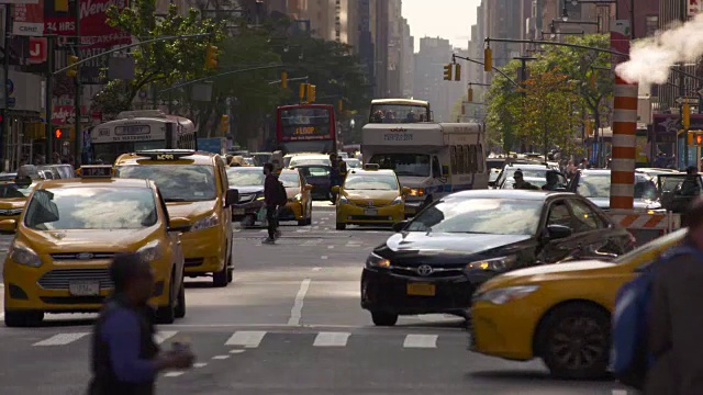 繁忙的纽约大街。汽车、骑自行车的人和行人穿过这个框架。蒸汽从一个橙色的管子里冒出来。视频素材