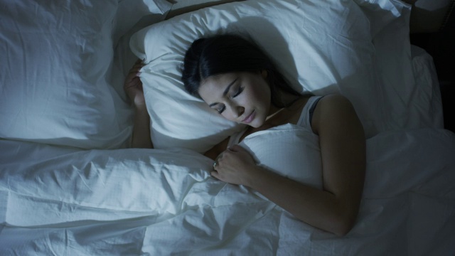 中高角度缩放拍摄的女人睡在床上/雪松山，犹他州，美国视频下载