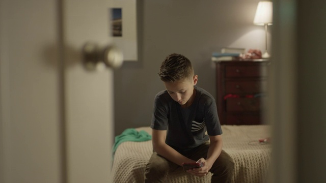 为了保护隐私，男孩用手机关闭卧室门的中镜头/美国犹他州雪松山视频下载