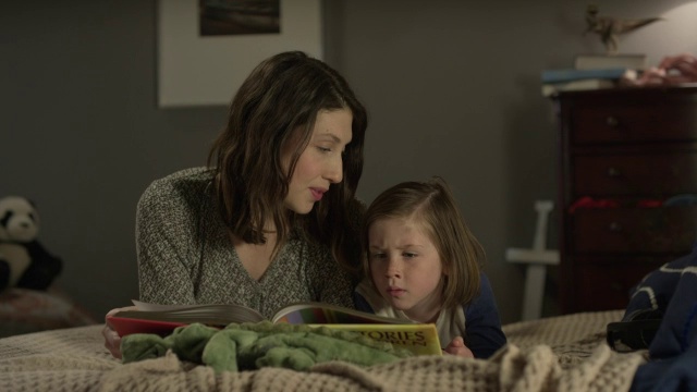 美国犹他州雪松山，母亲在床上给儿子看书的中镜头视频下载