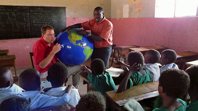 黑人+白种人拿着地球+对黑人学生讲课/肯尼亚视频素材