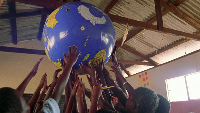 MS组的黑人学童在空中举着地球/肯尼亚视频素材