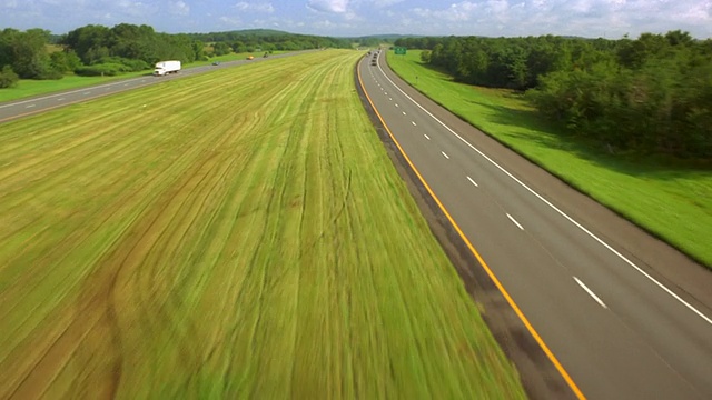 从空中俯瞰高速公路，穿过绿色的田野，向北行驶在纽约州高速公路上视频下载
