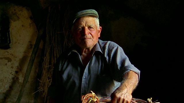 一名表情严肃的男子坐在谷仓里，西西里岛视频下载