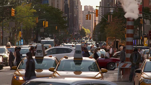 人们和汽车挤满了繁忙的纽约街道，并在缓慢移动。视频素材
