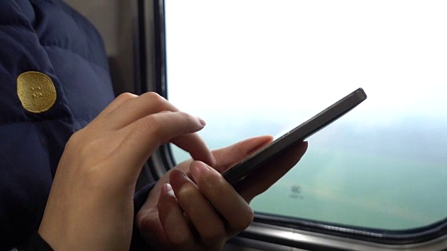 一个女人在火车上用手机视频下载