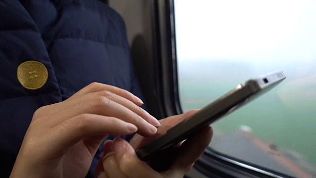 一个女人在火车上用手机视频下载