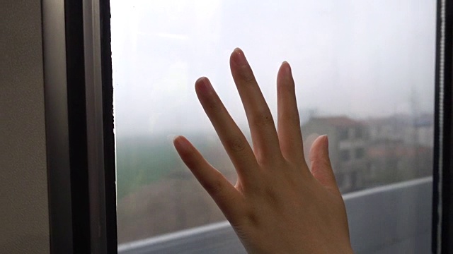 一个女人在火车上用手触摸车窗视频下载