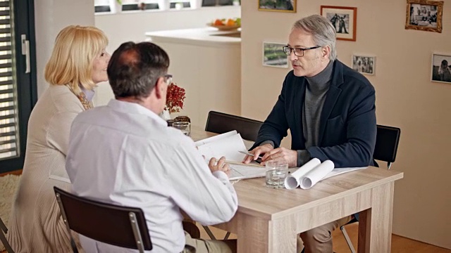 一位男建筑师在老夫妇家里开会时与他们握手视频素材