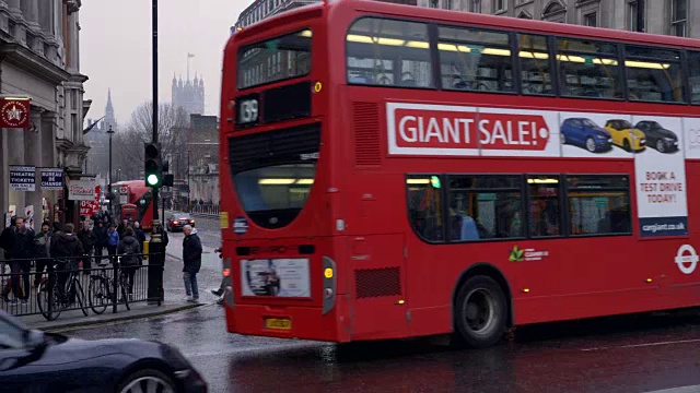 在伦敦白厅，汽车和公共汽车慢动作地驶过，伴随着小雨视频下载