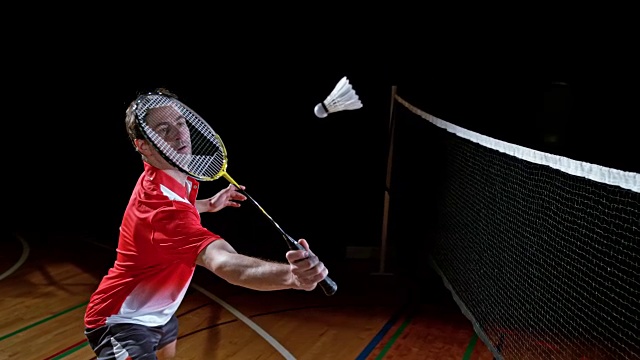 SLO MO男子室内羽毛球运动员击打羽毛球视频下载