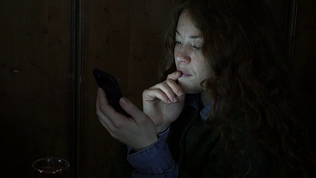 智能手机的灯光照亮了女人的脸视频素材