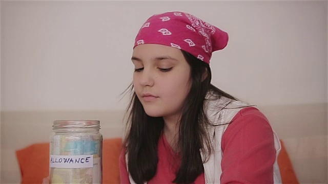 十几岁的女孩把钱放进储蓄罐里视频下载