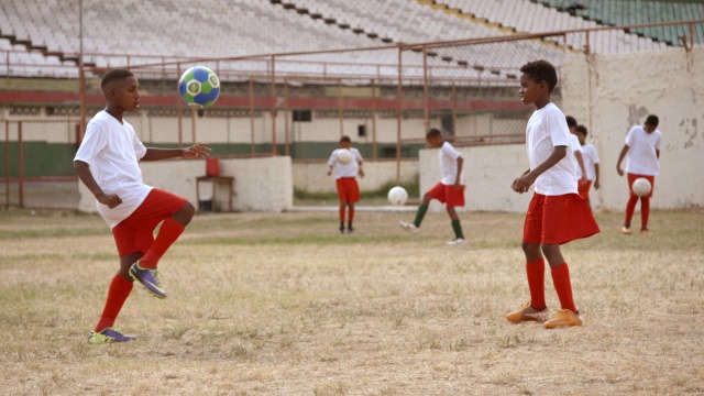 巴西的孩子们在旧足球场练习杂耍和传球足球视频下载